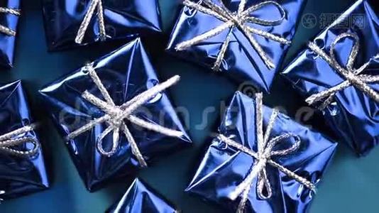 蓝色背景上的蓝色礼盒。 圣诞节和新年的旋转背景。 现在，惊喜的概念视频