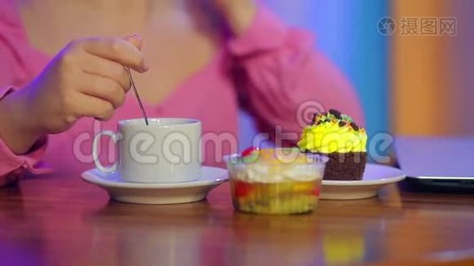 一个已婚的犹太人在一家咖啡馆里用咖啡和糕点在餐桌上打电话视频