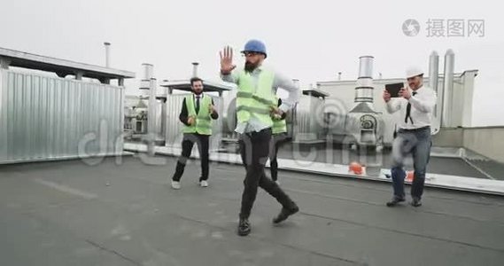 一个戴着眼镜、留着胡子的建筑高手，在他的工人朋友面前跳着现代舞，也都是视频