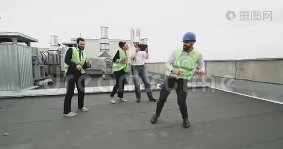 一个令人钦佩的建筑工人和他的朋友在一个建筑屋顶上享受他的时光，而一个人如果一个白人视频