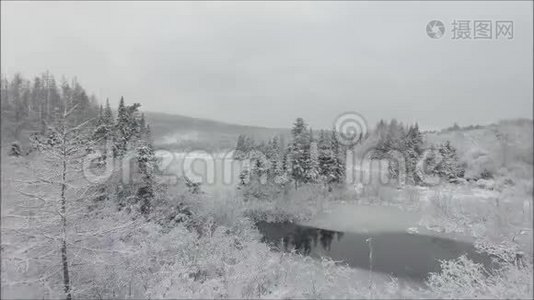 令人惊叹的空中无人机飞行在白雪覆盖的湖河上，在寒冷的冬天，山山景观上有松树视频