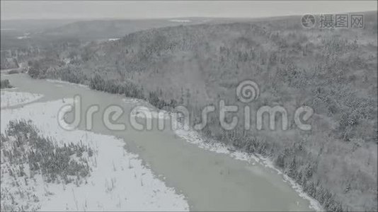 冰雪覆盖的湖泊河上华丽的空中无人驾驶飞机在寒冷的冬季山岭景观中飞过松树视频