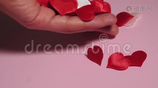 红心在粉红色的背景上，手摆出红心。爱情概念，情人节视频
