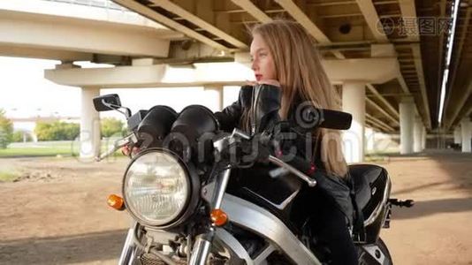 穿黑色摩托车皮夹克的少女。 骑摩托车的比基尼女郎。 在漂亮的摩托车上视频