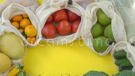 五颜六色的水果和蔬菜在可重复使用的袋子在黄色的背景。 零浪费。 减少塑料废物概念视频