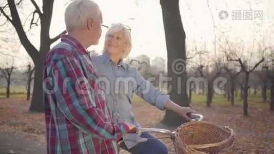 快乐的高白种人女人站在秋天的公园里，看着她可爱的丈夫。 成熟的退休夫妇视频