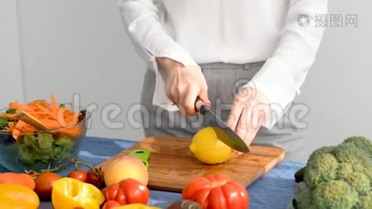 女人正在厨房的木切割板上切柠檬。视频