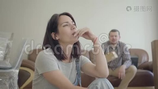 愤怒的高加索女人坐着，看着她的丈夫或男朋友在后台大喊大叫。 关系视频
