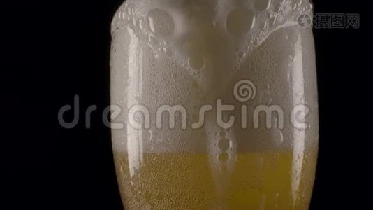 啤酒泡沫倒在杯边。视频