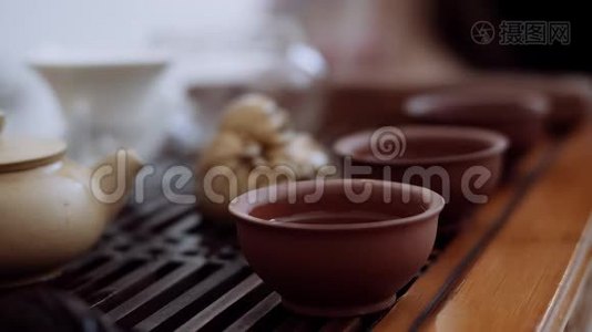 中国茶道，桌上是三杯，他们从一个水壶里倒出来。 特写视频