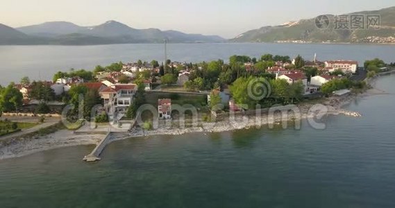 一个美丽的小镇在湖上的空中镜头，地平线上的群山，4k视频