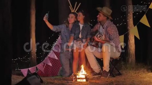 亲戚们的照片，微笑着的一家人在森林里度假时用火自拍wigwam的背景视频