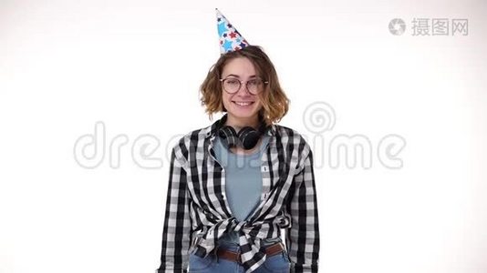兴奋的年轻女子穿着格子衬衫，戴着耳机，戴着生日礼物，戴着五颜六色的帽子，吹着烟斗，飘落下来视频