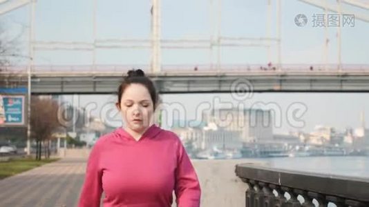 在河边和城市桥上进行北欧步行训练的迷人女士的前跟镜头。 健康概念视频