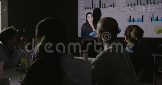 年轻的商业女性团队负责人在投影仪上展示项目策略。视频