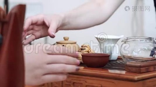 中国的茶道仪式上，女孩们用手从木桌上拿着小茶杯视频