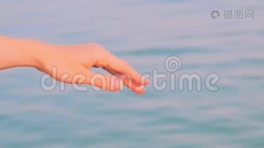 女性的手靠着海水做波浪运动。暑假概念视频
