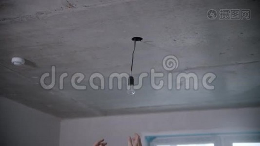 `人的手拧开天花板下的灯泡视频