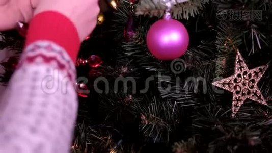 女人用圣诞灯把圣诞装饰放在树上。 节假日和新年的概念..视频