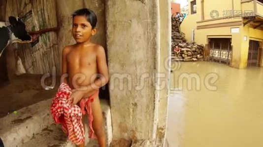 小印度男孩在楼梯上用干净的红色物质，脏水，洪水，圣河，恒河，成堆的紫檀木，擦拭他湿漉漉的身体视频