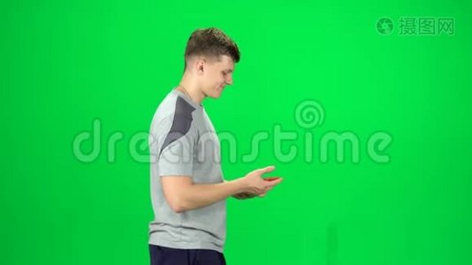 男人去和自拍与智能手机在绿色屏幕上的工作室。 侧视图视频