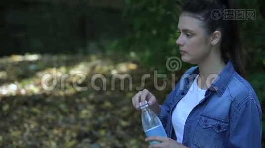 粗心的女性消费者在森林里扔水瓶，塑料垃圾视频