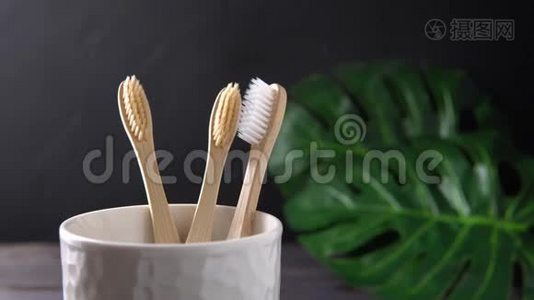 一只雄性的手把竹子牙刷放进一个白色的杯子里。视频