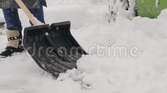 一个拿着铲子的人在他的车周围擦干净的雪。 在雪地里。视频