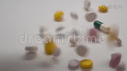 大量不同种类的药丸缓慢地落在白色背景上。视频