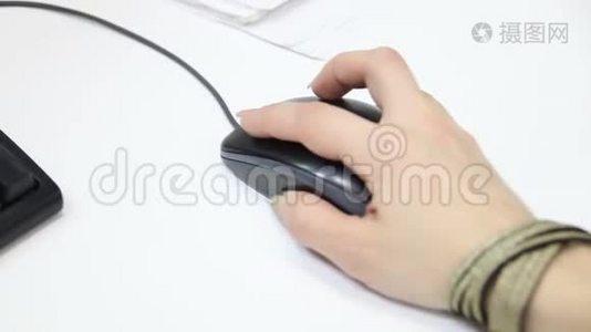 商人滚动鼠标和点击鼠标，并在办公室的电脑上工作。 把手放在老鼠身上。视频
