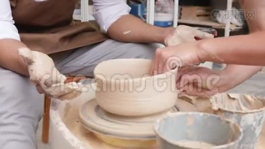 制作米色粘土特写花瓶。 作坊里的雕刻家用粘土做罐子. 扭曲的锅`轮子视频