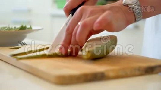 手把女人的梨切在木板上，素食成分，烹饪成熟的水果板，烹饪食物，新鲜健康的刀视频