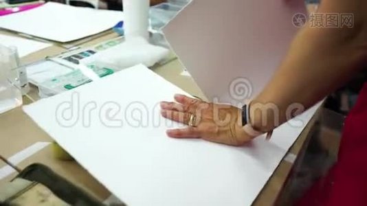 艺术家在准备用水彩和粉笔画画的纸的过程中。视频