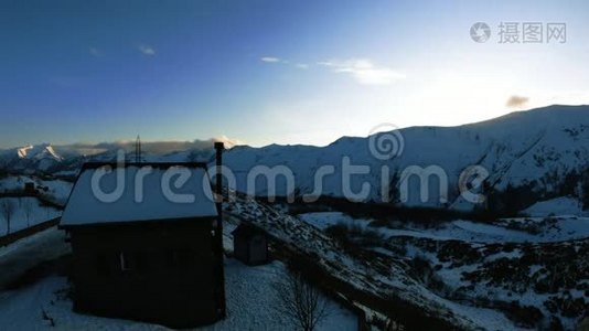 时间流逝的日落在雪山上有一座乡村的房子.视频