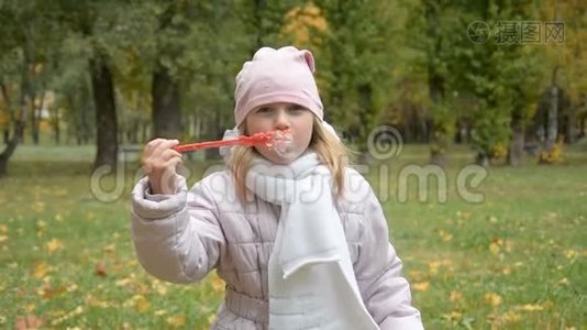 有趣可爱的小女孩吹肥皂泡的肖像视频
