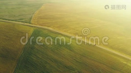 通过田野和夏季绿色草地景观鸟瞰公路道路。 高速公路上汽车运动的俯视图视频