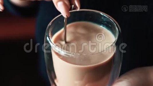 用勺子搅拌咖啡的女孩用牛奶特写视频