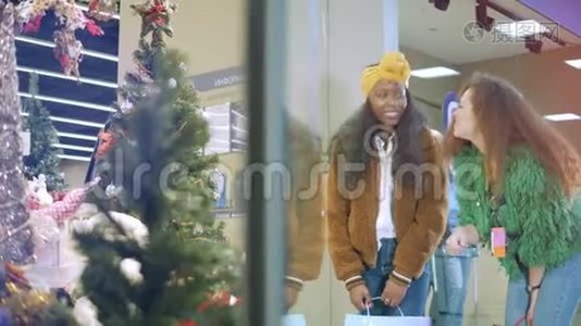 两个朋友在商店橱窗里检查圣诞装饰品。视频