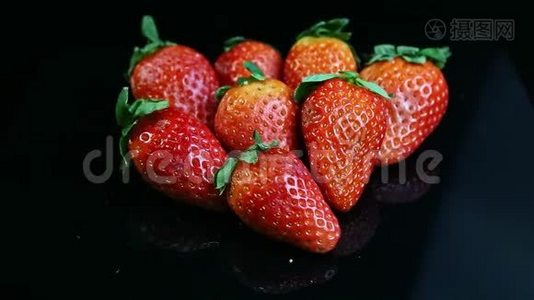 黑色背景下新鲜多汁红草莓群俯视图视频