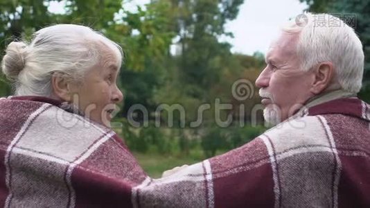 令人惊讶的年长妇女看着丈夫说闲话，一对在地毯下的夫妇视频