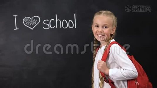 我爱学校写在黑板上，可爱的女孩站在旁边，小学教育视频