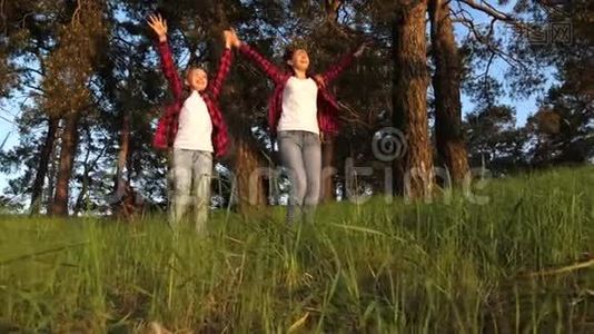 快乐的孩子们旅行，在公园里散步，在胜利中快乐，举起双手。 徒步旅行者女孩。 青少年旅行视频