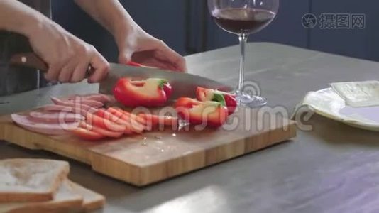 女人在厨房的木板上用锋利的刀把俱乐部三明治切成两半，在家里做快餐视频