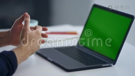 特写商人在视频会议上讲话。 一个绿色屏幕笔记本电脑视频