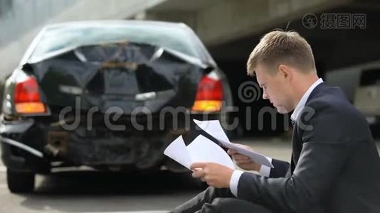 车祸后，男司机坐在路上看保险合同视频