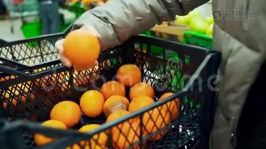 超市里的一个女人从一个盒子里拿出橘子放进一个袋子里。 把橘子放进抽屉里。视频