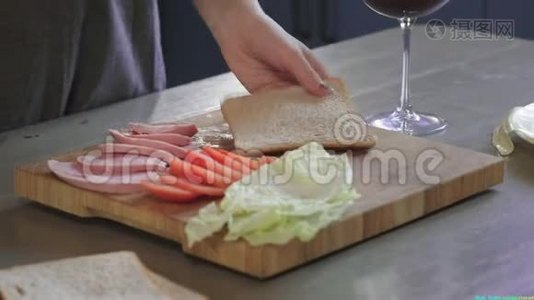 女人在厨房的木板上用刀把俱乐部三明治切成两半，在家里做快餐，厨师是视频