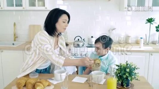 快乐的母亲。 一位为儿子准备健康早餐的母亲视频
