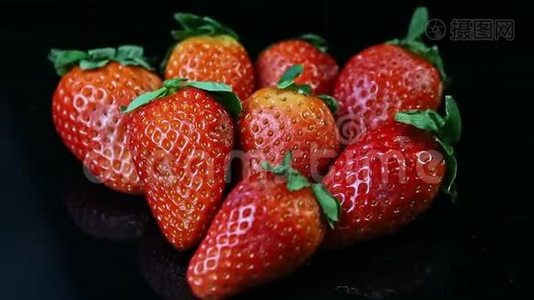 把焦点从一组新鲜多汁的红色草莓放在黑色的背景上视频
