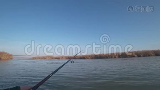 一个渔夫在一条河上的一条小船上钓到了一条食肉鱼，第一人称视角视频
